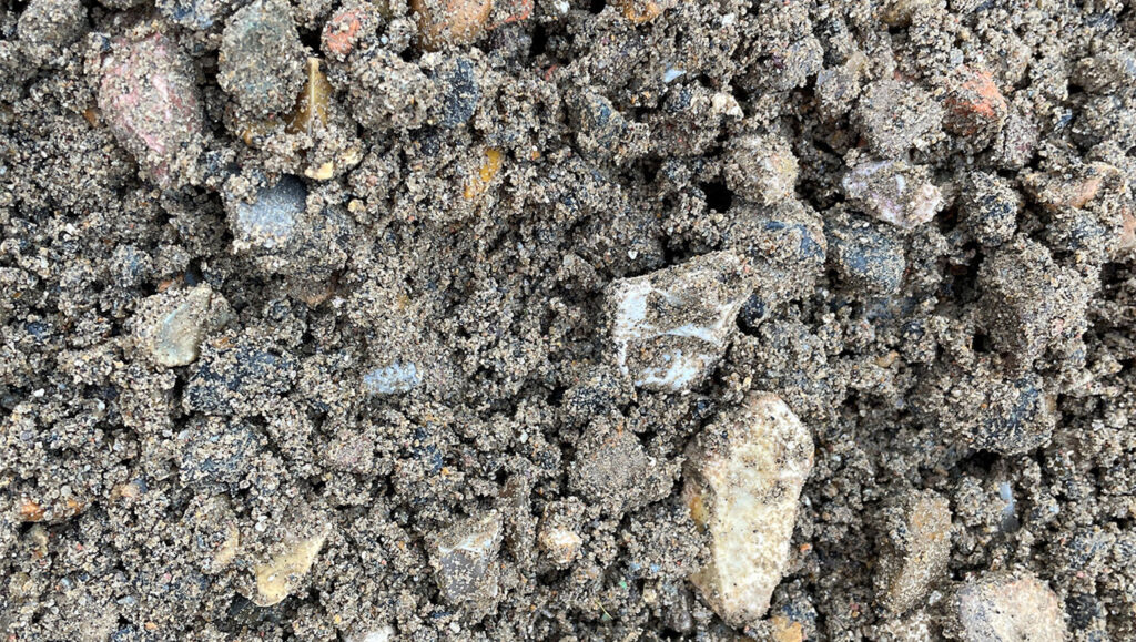 Close-up of coarse 0/20 recycled aggregate with small stones and gritty brown-grey particles, from Runfold, Farnham, Surrey.