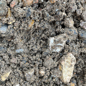 Close-up of coarse 0/20 recycled aggregate with small stones and gritty brown-grey particles, from Runfold, Farnham, Surrey.