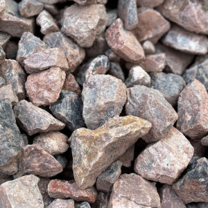 Close-up of rough, mixed grey, pink, and brown Type 1 Limestone Clause 803 aggregate in Runfold, Farnham, Surrey.