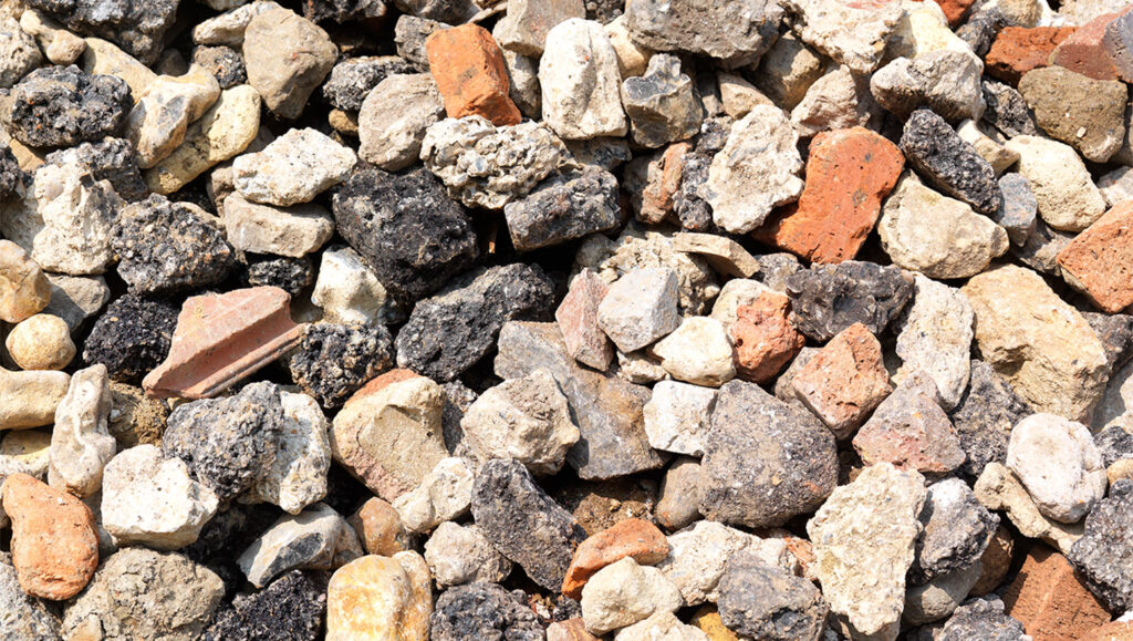 Close-up of 20/40 recycled aggregate in Runfold, Surrey: uneven lumps of concrete, brick, and stone in various sizes and colours.