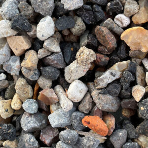 Close-up of 4/10 recycled aggregate from Runfold, Surrey; mixed grey, brown, black, and orange rocks and pebbles.