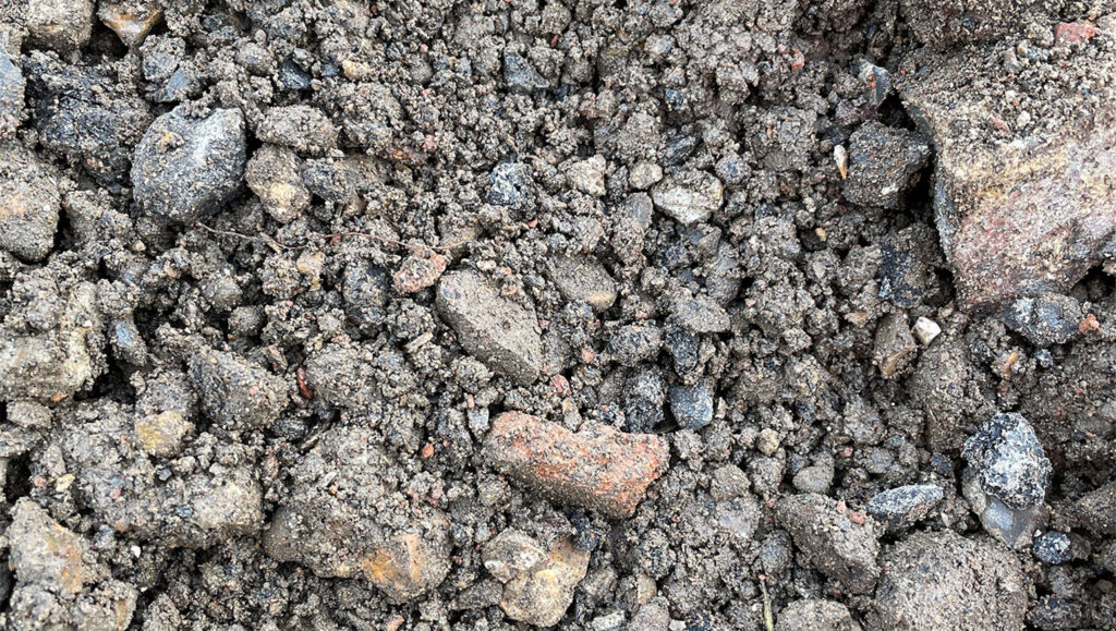 Close-up of Type 1 Reblend 50/50 SHW Clause 803 in Runfold, showing coarse soil with varied stones in brown, grey, and orange.
